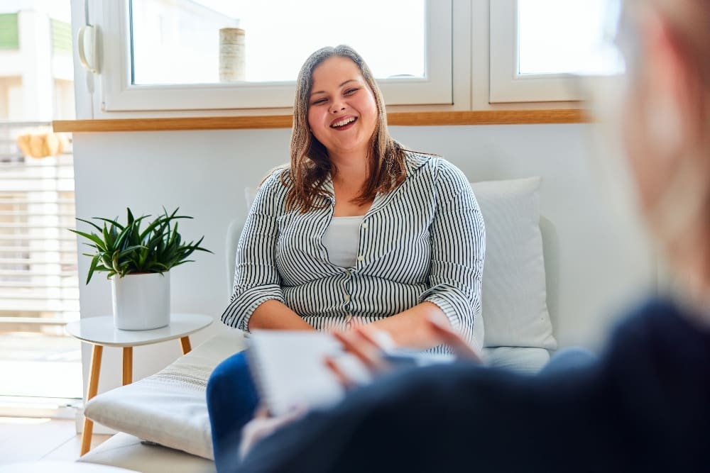 smiling woman talking with therapist about php vs residential rehab
